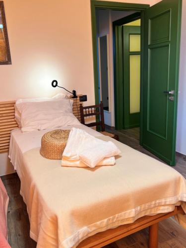 a bedroom with a bed with a straw hat on it at Villa Lilli Beta Bella in Neive