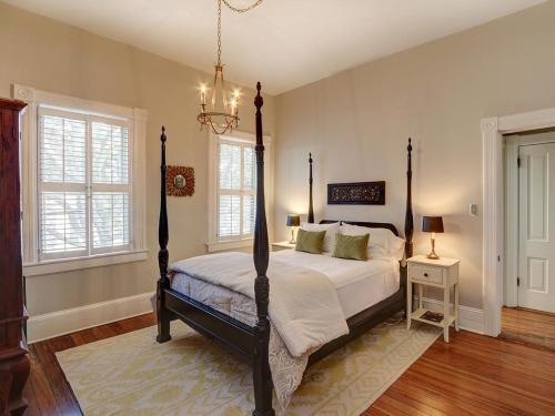 a bedroom with a bed and a chandelier at Luxury on Lincoln in Savannah