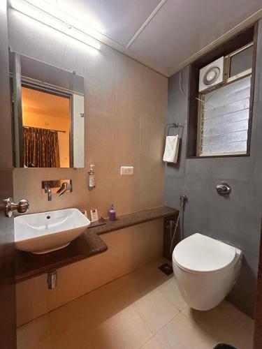 a bathroom with a white toilet and a sink at Marvella Stays in Anjuna