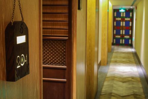 a door with a sign on it next to a hallway at LN Hotel Five in Guangzhou