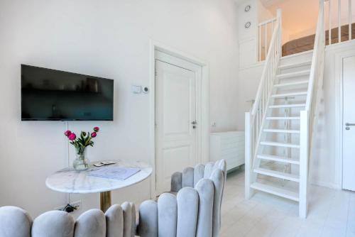 un soggiorno bianco con tavolo e sedie di B&B Cleyn Cruysenborgh 1531 a Dordrecht