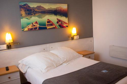 a bedroom with a bed and two paintings on the wall at Hotel La Casa Del Abuelo in Tapia de Casariego