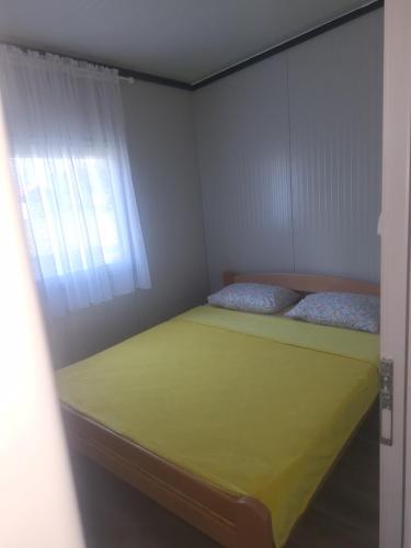 a small bedroom with a bed and a window at Auto camp Čarobna ravnica in Podgorica