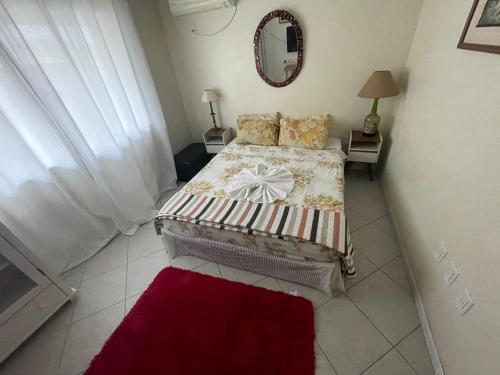 a small bedroom with a bed and a mirror at A Pérola do Gravatá in Navegantes