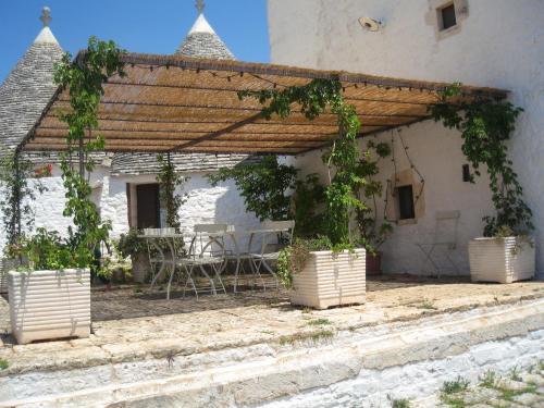 an outdoor patio with a pergola and a table at Masseria Colombo in Mottola