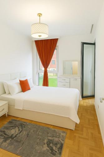 een witte slaapkamer met een groot bed en een raam bij Peja Central Hideaway in Peje