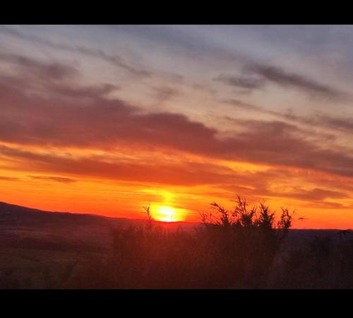 a sunset with the sun setting on the horizon at HILL's ROOM in Vescona