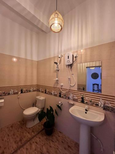 a bathroom with a toilet and a sink and a mirror at Star Eyes in Weligama