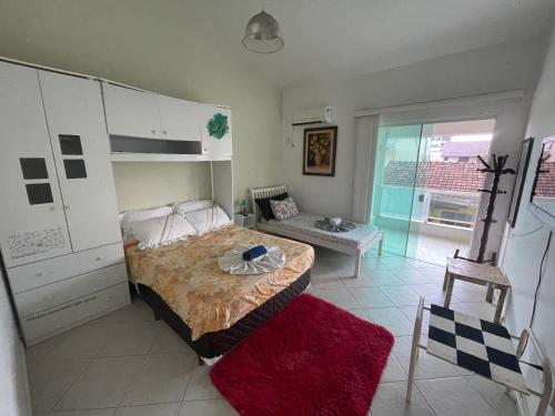 a bedroom with a bed and a table in it at A Pérola do Gravatá in Navegantes