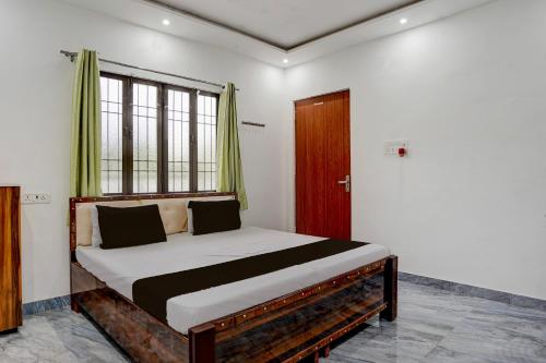 a bedroom with a large bed with a window at Hotel O Ujala Guest House in Varanasi
