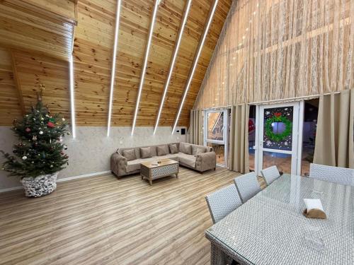 a living room with a couch and a christmas tree at bag evi in Mardakan