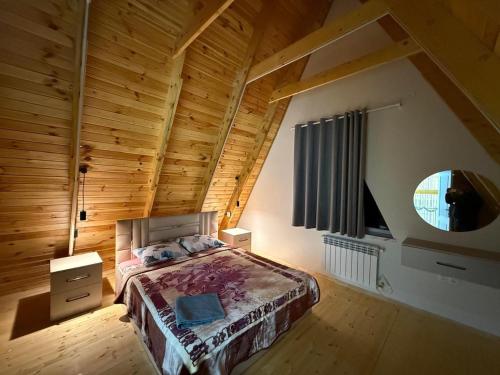 a bedroom with a bed with a wooden ceiling at bag evi in Mardakan