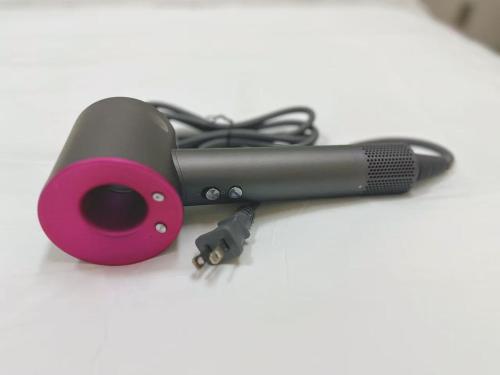 a hair dryer with a pink holder on a table at Shinjuku Downtown新宿 in Tokyo