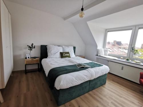 ein Schlafzimmer mit einem Bett und einem großen Fenster in der Unterkunft Königstraße Apartments in Nürnberg