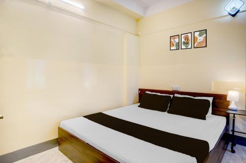 a bedroom with a bed with white and black sheets at Collection O GNRC Hospital Dispur Formerly Shree Vinayak Guest House in Guwahati