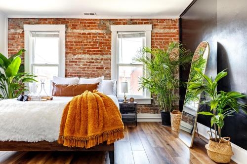 a bedroom with a brick wall with plants at Short North Convention Private Parking Pets! in Columbus
