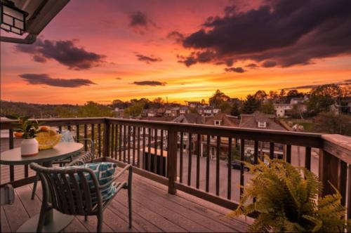 a balcony with a table and chairs and a sunset at 3BR Stylish Retreat, Minutes from Downtown Pittsburgh, Free 3-Car Parking in Pittsburgh