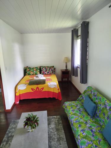 un salon avec un lit et un canapé dans l'établissement 3R Lodge Bungalows, à Toanoano