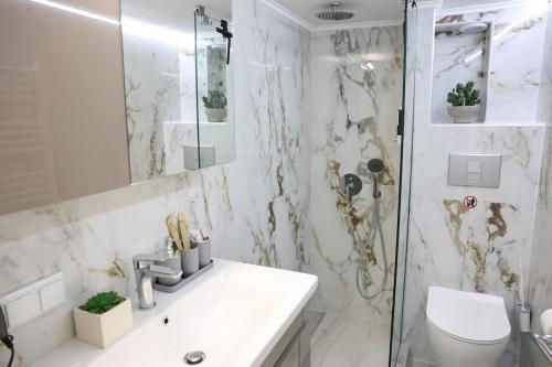 a white bathroom with a sink and a shower at Modern Apartment G66 in the Center in Drama