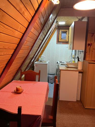 a room with a table and a kitchen in a house at Vikendica Jahorina J&K in Pale