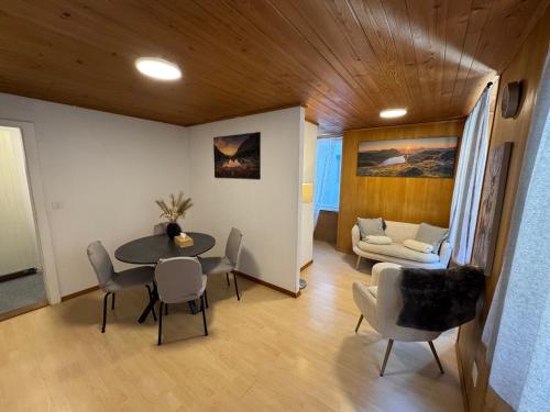 a living room with a table and chairs and a couch at Blue Sky Apartments in Göschenen