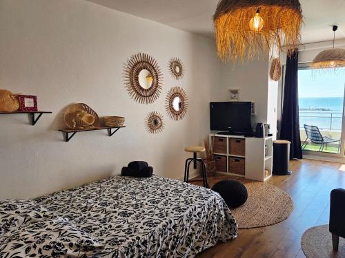 a bedroom with a bed and mirrors on the wall at Studio plein sud le ciel le soleil et la mer in Palavas-les-Flots