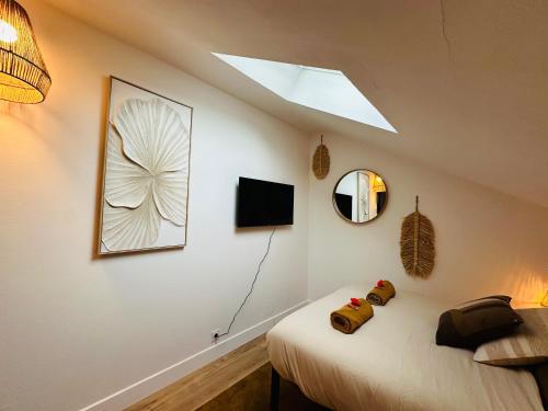 a bedroom with a bed and a mirror and a skylight at Le Champêtre - Centre du Rheu in Le Rheu