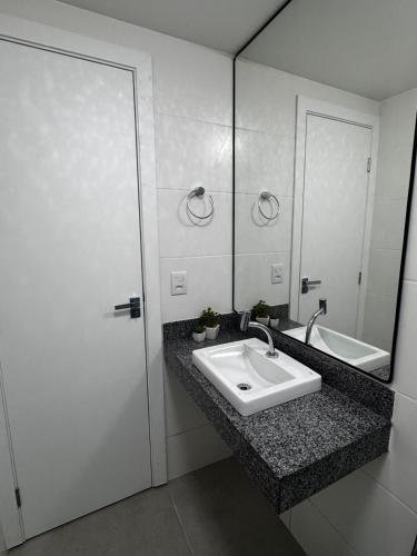 a bathroom with a sink and a mirror at Studio em Belém perto do Shopping Bosque e Parque da Cidade in Belém