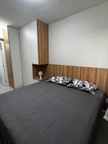 a bedroom with a large bed with a wooden headboard at Studio em Belém perto do Shopping Bosque e Parque da Cidade in Belém