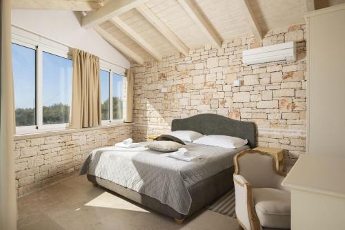a bedroom with a bed and a brick wall at Villa Mason with Heated Pool and mini Wellness in Rovinjsko Selo