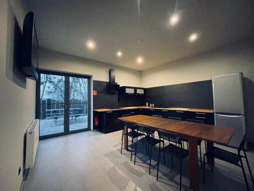 a large kitchen with a wooden table and chairs at KWADRAT hostel 