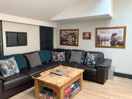 Una sala de estar con un sofá de cuero y una mesa de café. en The Old Bakery - Luxury Three Bed House with Roof Terrace, en Whitby