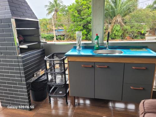 a kitchen with a sink and a window at Pousada do Sossego Mar e verde 3 in Itanhaém