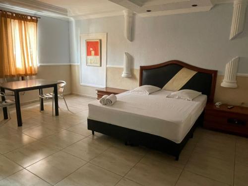 une chambre avec un lit, une table et un bureau dans l'établissement Hotel Vitória de Santos, à Santos
