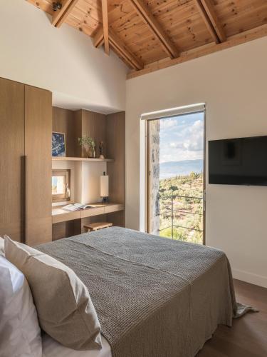 a bedroom with a large bed and a large window at Terra Maina Villa in Avía