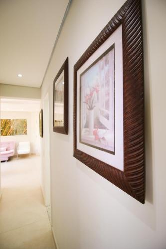 a hallway with three framed pictures on a wall at Apartamento Confortável e Acolhedor in Diamantina