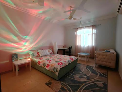 a bedroom with a bed and a ceiling with lights at Bloom Flat in Muscat