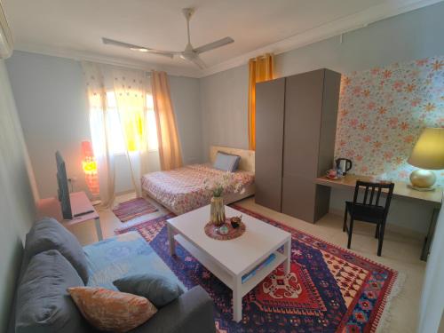 a living room with a couch and a table at Bloom Flat in Muscat