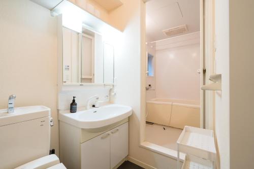 a white bathroom with a sink and a toilet at ハイツNagomi in Otsu