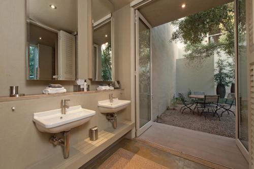 a bathroom with two sinks and a walk in shower at Mosselberg on Grotto Beach in Hermanus