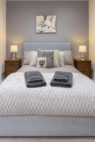 a bedroom with a bed with two towels on it at Erskine Apartment-Small and Cosy 1 Bedroom Apartment in Angus