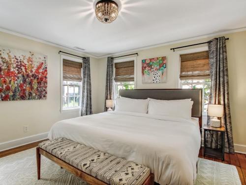 Un dormitorio con una gran cama blanca y ventanas. en Courtyard Off Madison Square, en Savannah