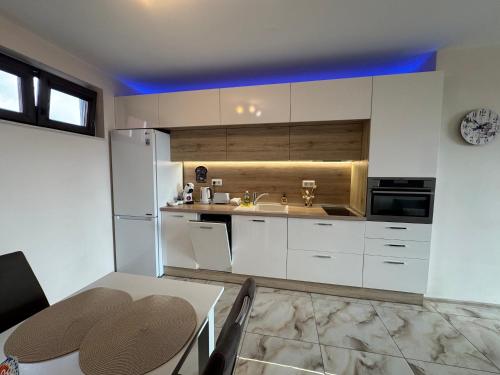 a kitchen with white cabinets and a table and a sink at Breathtaking sea view apartment in Varna City