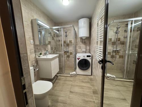 a bathroom with a shower sink and a washing machine at Breathtaking sea view apartment in Varna City