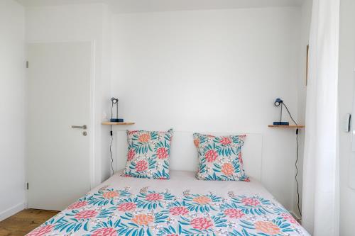 a small bedroom with a bed with colorful pillows at Cosy T4 proche hyper centre in Vannes