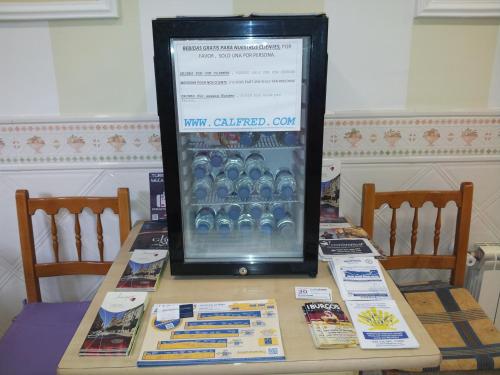 a table with a display of a drink cooler on it at Pensión Calfred II in Logroño