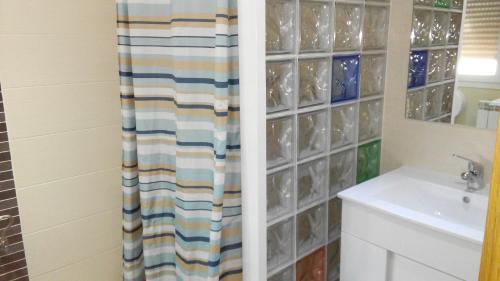 a bathroom with a shower curtain next to a sink at Pensión Calfred II in Logroño