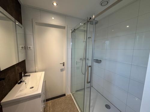 a bathroom with a glass shower and a sink at Enkhuizer Strand Chalet Leuke Plek Haus Nr 216 in Enkhuizen