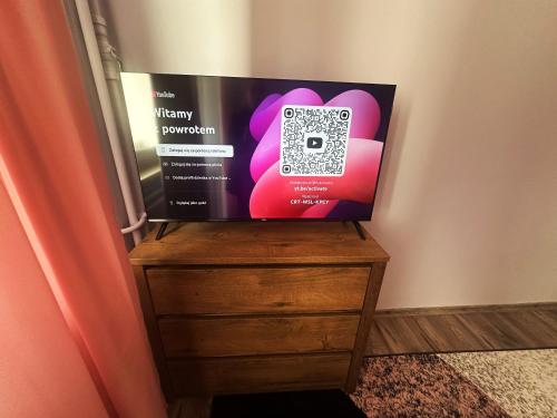 a television sitting on top of a wooden dresser at Wypoczynek Między Świerkami in Ustroń