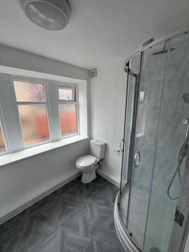 a bathroom with a toilet and a glass shower at Manchester Guesthouse in Manchester